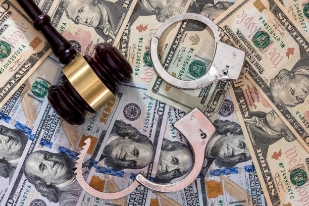 istock Steel handcuffs with judge's gavel on dollar banknotes 1058274752