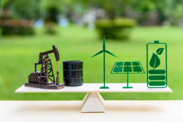 combustibles fossiles vs concept propre énergie renouvelable / futur : puit de pétrole, pétrole brut tambour, panneau solaire, batterie de feuille verte, éolienne sur une échelle de bois équilibre en position égale. - fossil fuel fuel and power generation fuel pump gasoline photos et images de collection