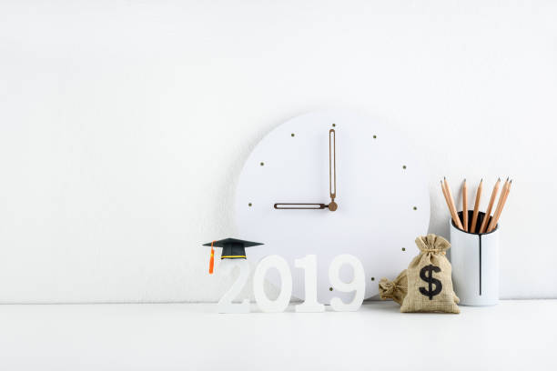 istock 2019 happy new year, graduate study abroad program, time schedule arrangement, education concept : Black graduation cap of success on number 2019 white wood cut on student desk, workplace office table 1058275144