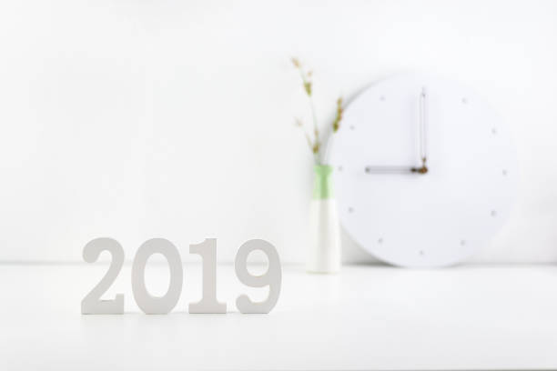2019 happy new year theme, professional designer office concept : Business work space / modern workplace and decorative supplies place on desk table e.g number 2019 white wood cut, wall clock, vase