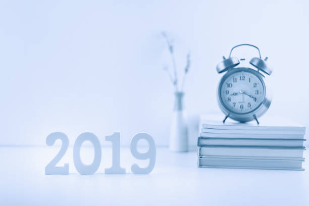 2019 happy new year theme, professional designer office concept : Business work space / modern workplace and decor supplies place on desk table e.g number 2019 white wood cut, timer clock, books, vase