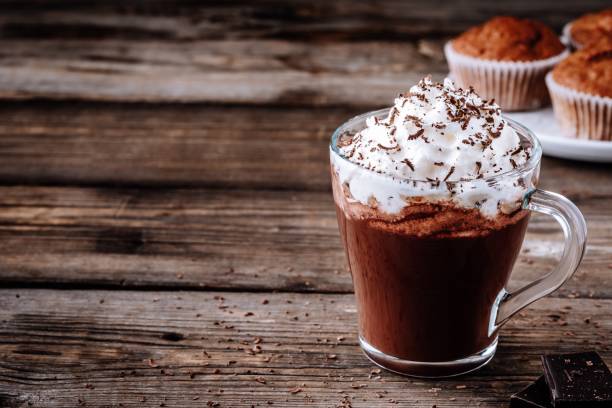 heiße schokolade trinken mit sahne in ein glas auf einem hölzernen hintergrund - kakao heißes getränk fotos stock-fotos und bilder