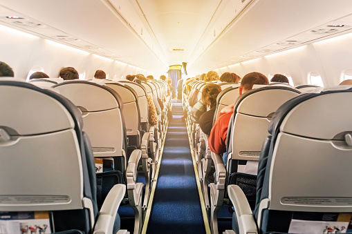 Cabina de aeronaves comerciales con filas de asientos por el pasillo photo