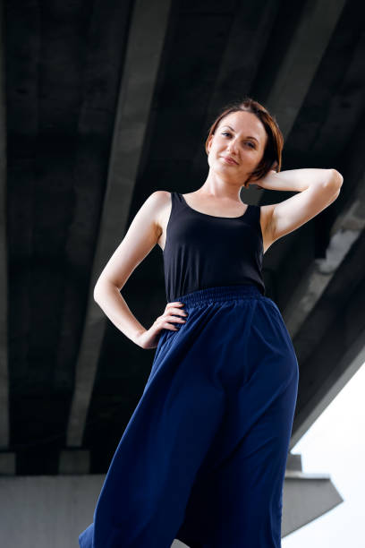 istock young girl posing under the bridge, dressed in black, modern architecture 1058289356