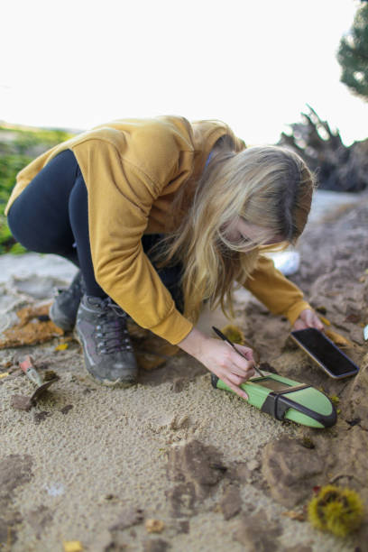 istock Final year female Geology student taking coastal rock samples and using a GPS to pin point her position in the South of England 1058290984