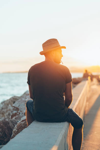 istock Man enjoying the sunset in the harbor 1058293612