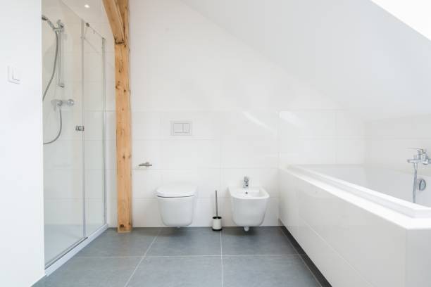 istock White loft bathroom with glass shower cabin. 1058294216