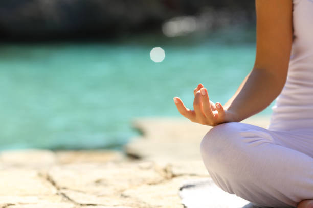 istock Woman practicing yoga exercises on the beach 1058294530