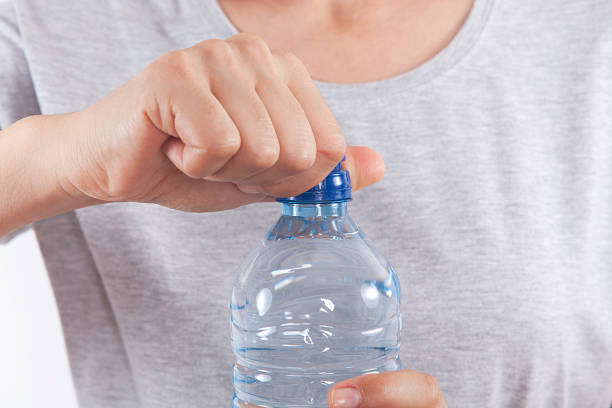 istock Young woman drinking water form a bottle at home. 1058297154