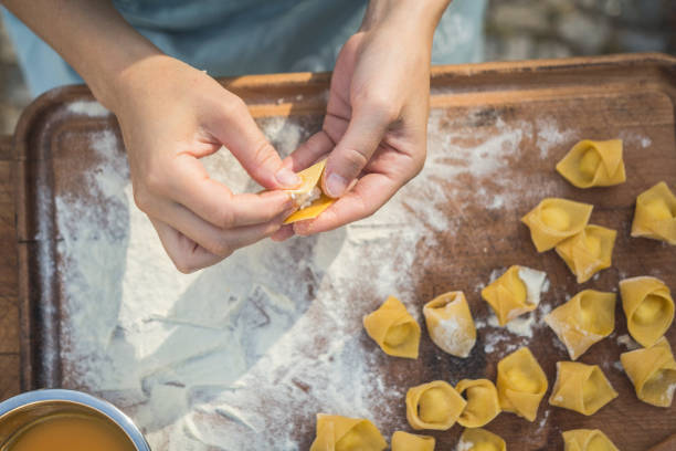 chef preparar tortellini de pasta rellena a mano - food industry manufacturing human hand fotografías e imágenes de stock