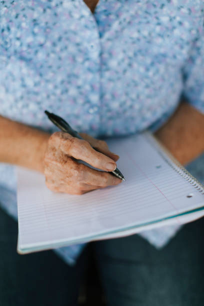 istock Senior woman writing down her memories into a notebook 1058302194