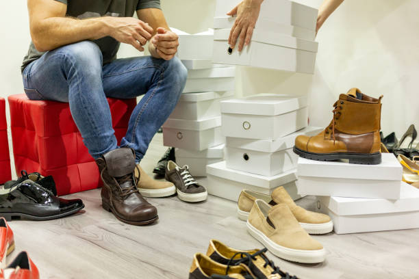 istock Man trying on boots in shoe shop 1058305768