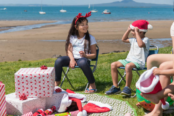 A candid photograph of children having fun during Christmas party celebrations on the beach in New Zealand