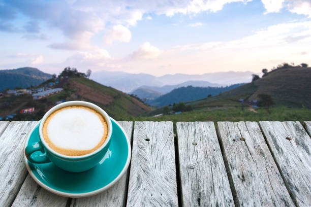 istock hot coffee on wood table,mountain blur background image, for product display montage. 1058309448