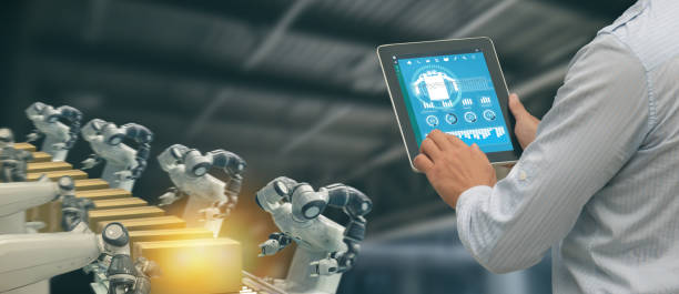istock iot industry 4.0 concept,industrial engineer using software (augmented, virtual reality) in tablet to monitoring machine in real time.Smart factory use Automation robot arm in automotive manufacturing 1058309862