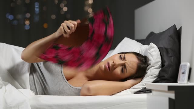 Woman suffering heat stroke in the night in the bed