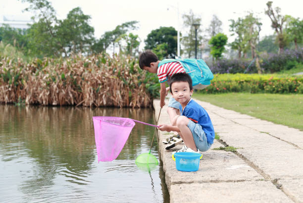 istock Child playing by a stream fishing 1058312616