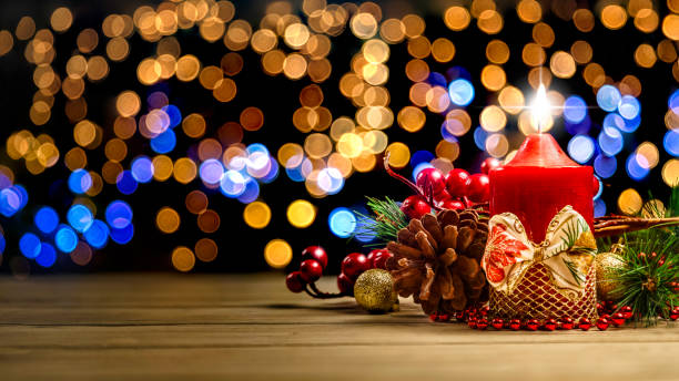 istock Low key of lit candle on defocused Christmas lighting background 1058313188