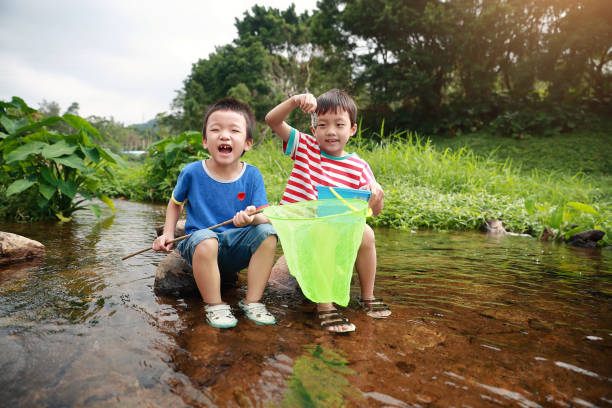 istock Child playing by a stream fishing 1058313600