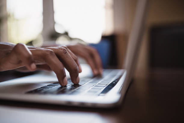 primo passo della digitazione della mano della donna nera sulla tastiera del laptop - log on foto e immagini stock