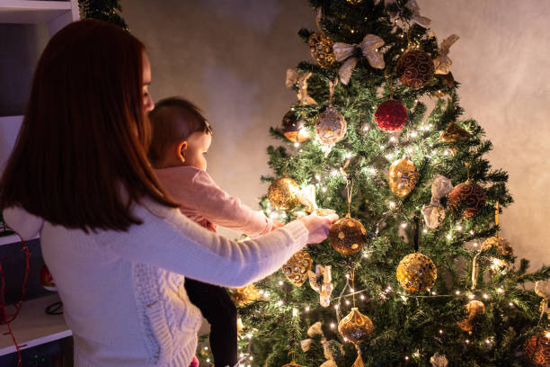 istock Mother and baby decorating Christmas tree 1058317340