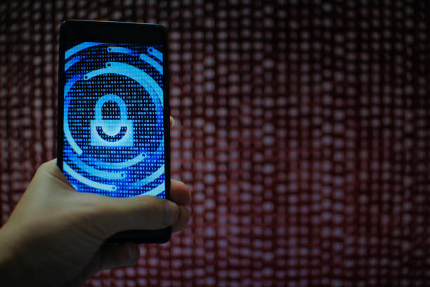 istock data privacy. surfing through hostile internet and hackers probe and bad government surveillance. blue padlock on mobile device on panel of red code led screen. hand holding smart phone. 1058320848