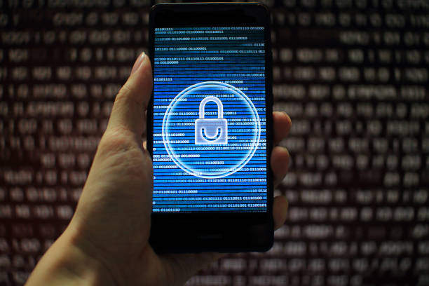 istock data privacy. surfing through hostile internet and hackers probe and bad government surveillance. blue padlock on mobile device on panel of red code led screen. hand holding smart phone. 1058320874