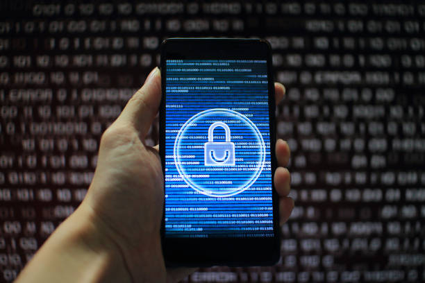 istock data privacy. surfing through hostile internet and hackers probe and bad government surveillance. blue padlock on mobile device on panel of red code led screen. hand holding smart phone. 1058320876