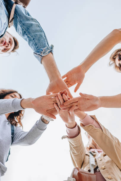 istock bottom view of young friends putting hands together 1058322418