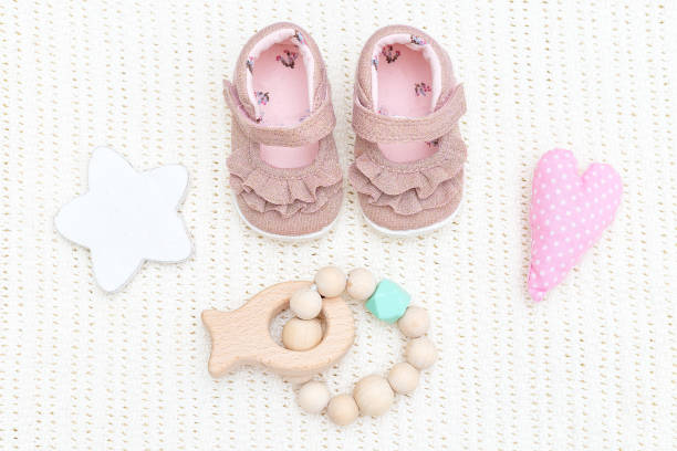 istock Baby pink shoes and wooden teether 1058326114