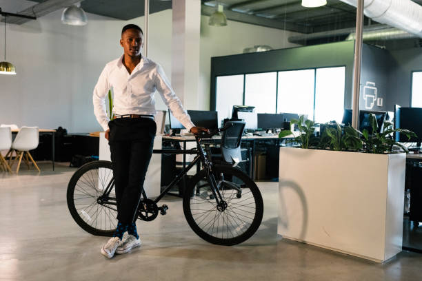 istock Full length portrait young businessman standing with bicycle inside 1058326128