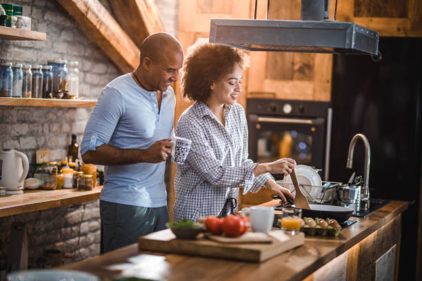 istock Happy African American couple enjoying while preparing breakfast in the kitchen. 1058328670