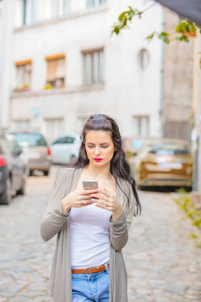 istock Cute young woman using cellphone in urban surroundings. 1058332428