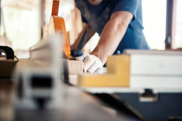 Carpenter sawing wooden planks