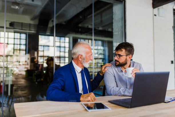 istock Senior businessman and mid adult man discussing work 1058333078