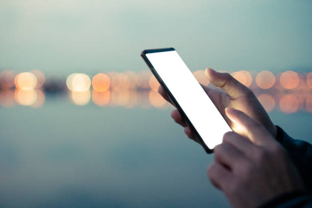 man hands using smartphone at night on city street. - business blurred motion text messaging defocused imagens e fotografias de stock