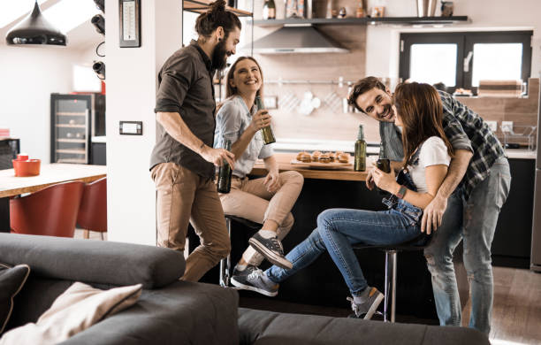 istock Two cheerful couples having fun while talking on a party at home. 1058336266