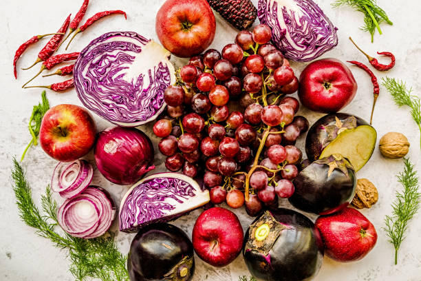 istock raw purple and red vegetables and fruit on white marble background top view 1058340724