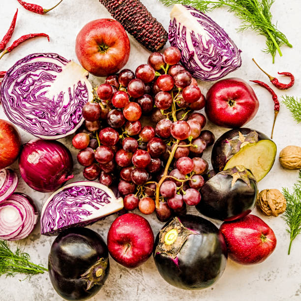 istock raw purple and red vegetables and fruit on white marble background top view 1058341118