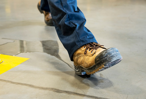An industrial, manufacturing, safety topic.  A worker slipping on liquid.