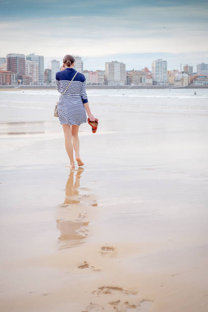 Woman walking on the beach with Smartphone