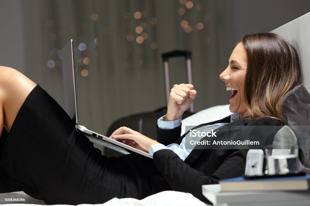 Emocionado de encontrar contenidos online en el hotel bussinesswoman - Foto de stock de Hotel libre de derechos Emocionado de encontrar contenidos online en el hotel bussinesswoman - Foto de stock de Hotel libre de derechos