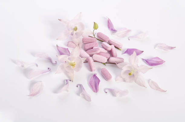 istock Alternative medicine tablets with flowers and petals on table 1058351380