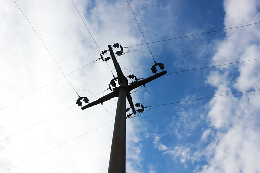 power supply lines crossing at a mast, low angle view