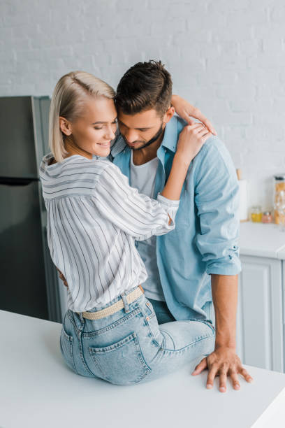 istock cheerful passionate young couple hugging in kitchen 1058360342