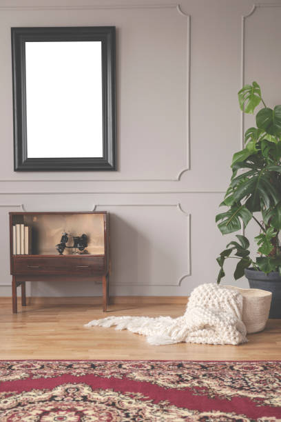 istock Mockup in black frame above vintage cabinet with books in elegant interior 1058363082