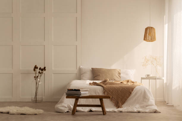 Beige blanket on the double bed in stylish wabi sabi bedroom of minimal style house, real photo with copy space on the empty wall Beige blanket on the double bed in stylish wabi sabi bedroom of minimal style house, real photo with copy space on the empty wall beige bedroom stock pictures, royalty-free photos & images