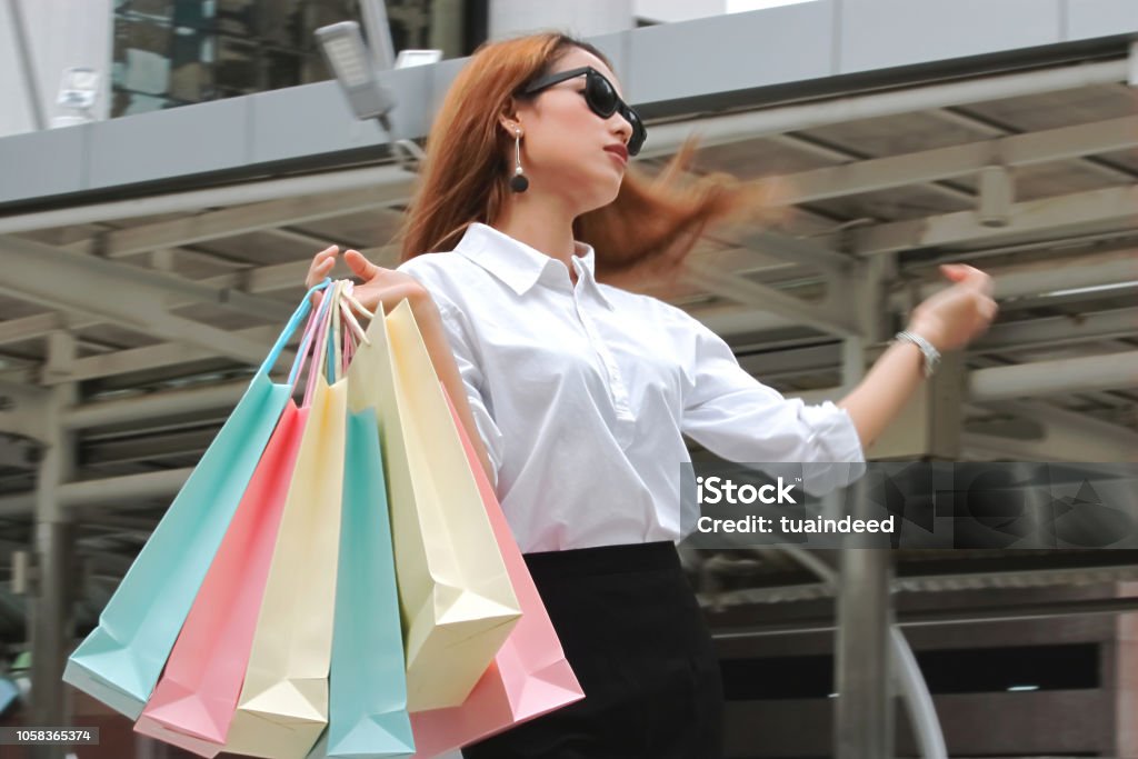 Attraktive junge Asiatin in Casual Kleidung tragen bunte Einkaufstaschen im freien - Lizenzfrei Asiatischer und Indischer Abstammung Stock-Foto