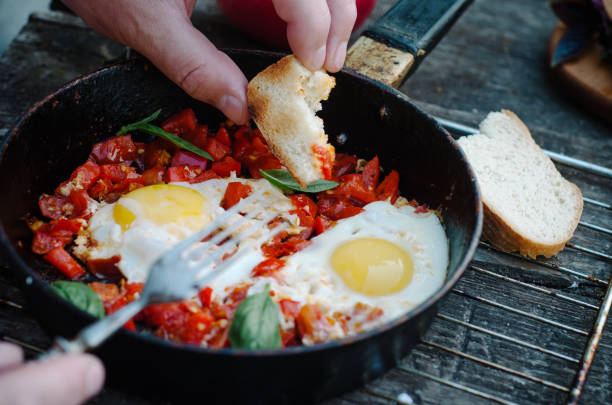istock Shakshuka, Fried Eggs with Tomato Sauce in a Pan, Rustic Style and Wooden Background 1058365876