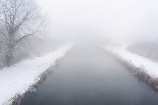 River in winter time with fog.